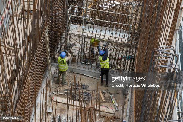 Workers at the massive shaft-like structure under construction during Portuguese Prime Minister Antonio Costa visit with the Minister of the...