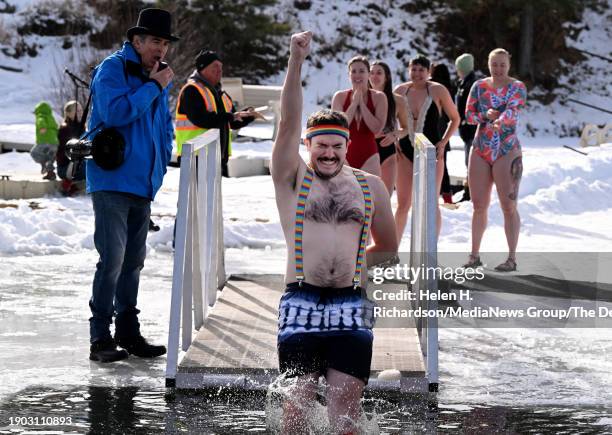 Plunger pumps his fist in the air as he jumps into the frigid waters during the annual Evergreen Lake Polar Plunge in Evergreen, Colorado on January...