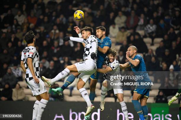 Boavista's Portuguese midfielder Miguel Reisinho jumps for the ball with FC Porto's Serbian midfielder Marko Grujic during the Portuguese League...