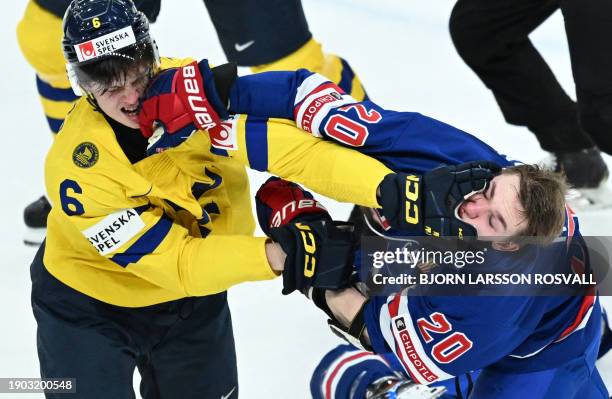 Sweden's defender Anton Johansson and USA's defender Lane Hutson clash during the final ice hockey match between USA and Sweden of the IIHF World...