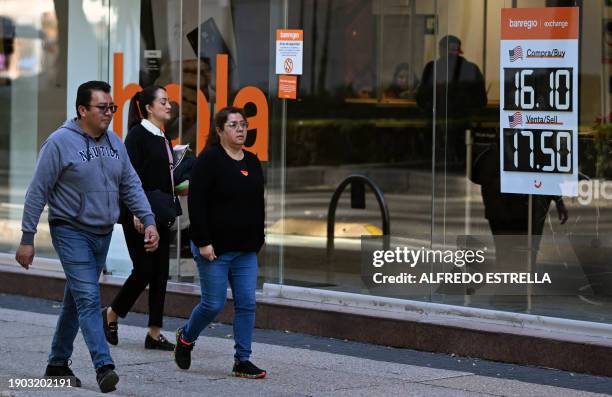 People pass by an exchange house at Reforma Avenue in Mexico City on January 5, 2024. In recent weeks, the Mexican peso has strengthened against the...