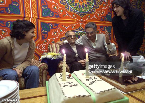 Egyptian novelist and nobel prize winner Naguib Mahfouz is surrounded by friends celebrating his birthday at a hotel in Cairo 13 December 2000....