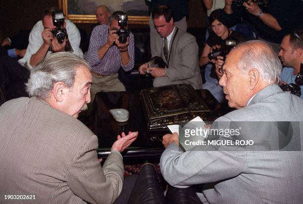 Uruguayan president Jorge Batlle engages in a discussion with Argentinan writer Juan Gelman 31 March 2000 in Montevideo, Uruguay, while being...