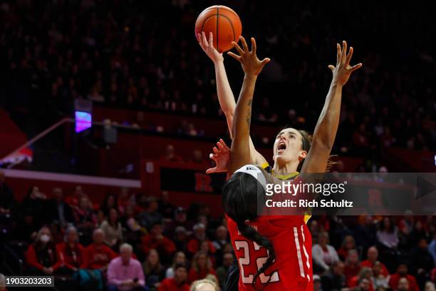 Caitlin Clark of the Iowa Hawkeyes attempts a shot as Kassondra Brown of the Rutgers Scarlet Knights defends during the first half of a game at...