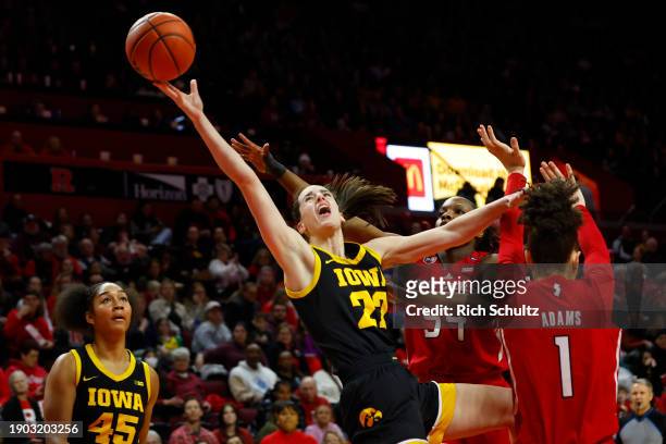 Caitlin Clark of the Iowa Hawkeyes attempts a shot as Chyna Cornwell and Destiny Adams of the Rutgers Scarlet Knights defend during the first half of...