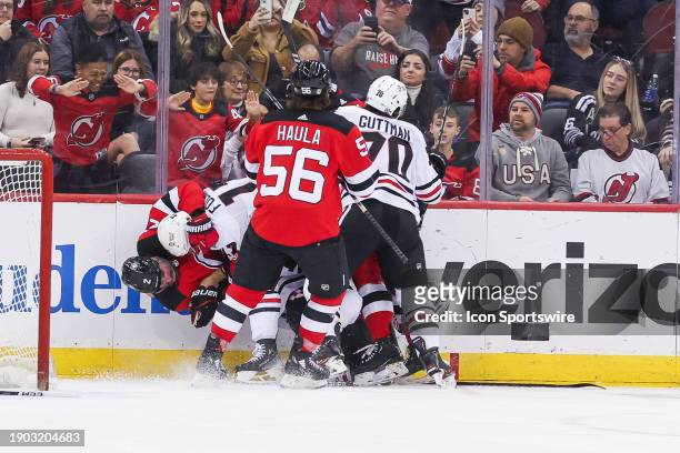 New Jersey Devils defenseman Brendan Smith and Chicago Blackhawks left wing Nick Foligno are involved in a scrum after Chicago Blackhawks center...