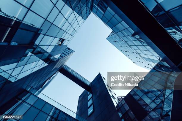 low angle of tall corporate buildings skyscraper with reflection - skyscraper abstract stock pictures, royalty-free photos & images