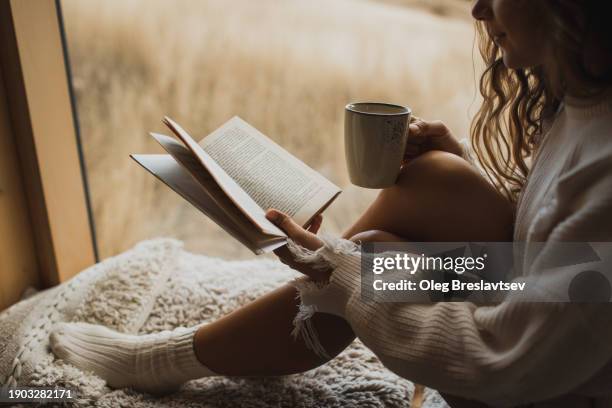 close up picture of book and coffee cup in woman hands. autumn mood, cosiness and comfort concept - hygge stockfoto's en -beelden