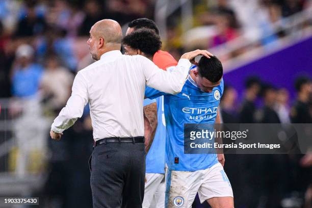 Manchester City Head Coach Pep Guardiola high five Phil Foden of Manchester City who was substituted during the FIFA Club World Cup Final match...