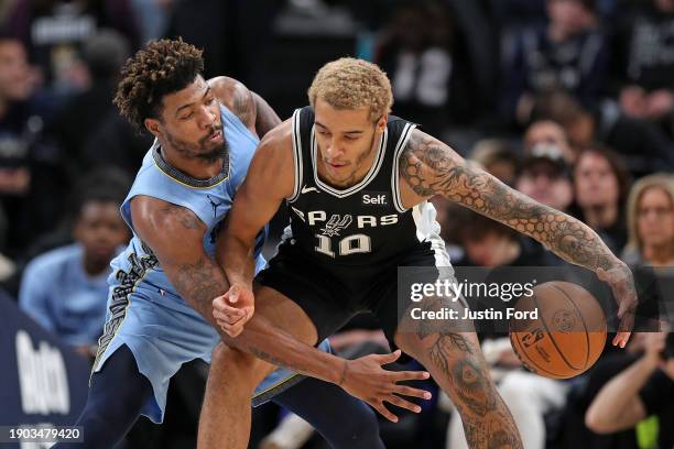 Marcus Smart of the Memphis Grizzlies guards Jeremy Sochan of the San Antonio Spurs during the first half at FedExForum on January 02, 2024 in...