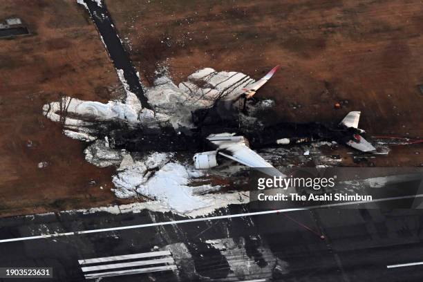 In this aerial image, the debris of Airbus A-350, Flight JAL 516 is seen a day after the collision with a Japan Coast Guard aircraft at Haneda...