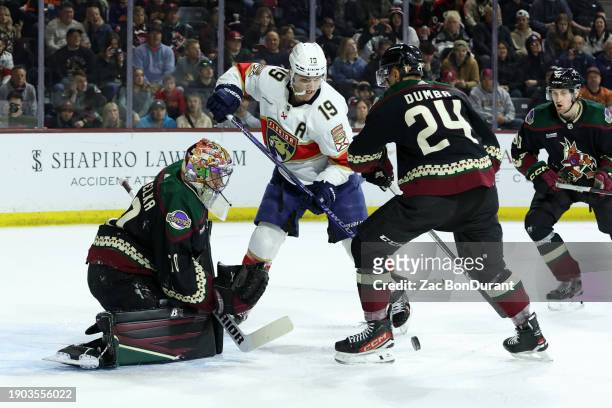 Matthew Tkachuk of the Florida Panthers defects a puck in front of Karel Vejmelka of the Arizona Coyotes during the first period at Mullett Arena on...