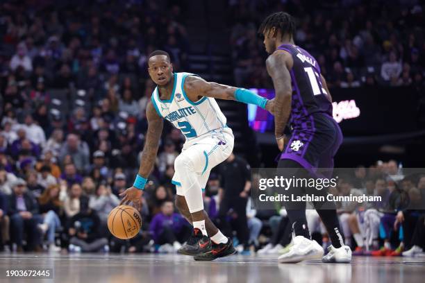 Terry Rozier of the Charlotte Hornets is guarded by Davion Mitchell of the Sacramento Kings in the second quarter at Golden 1 Center on January 02,...