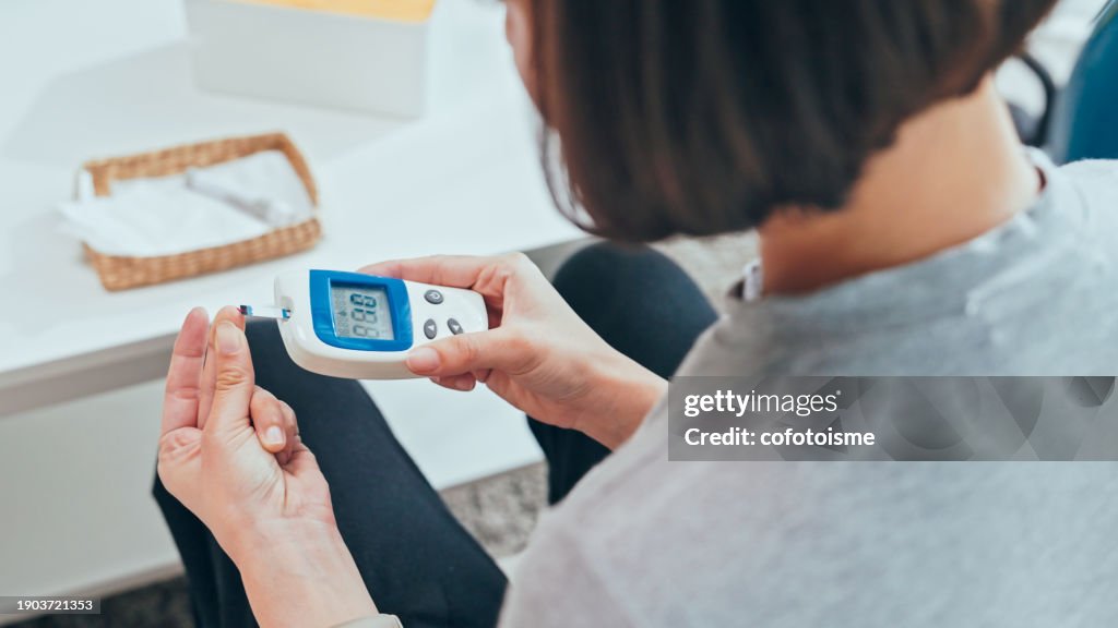 Young adult Woman doing a glucose blood test at home