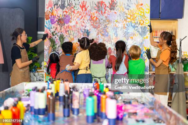 group of diversity school children learning acrylic art together in art class. - elementary age kids painting stock pictures, royalty-free photos & images