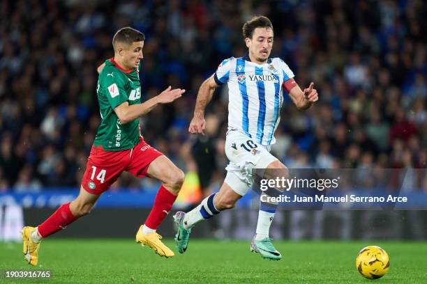 Mikel Oyarzabal of Real Sociedad duels for the ball with Nahuel Tenaglia of Deportivo Alaves during the LaLiga EA Sports match between Real Sociedad...