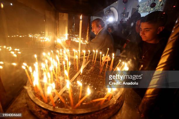 Orthodox Christians pray and light candles at the Church of the Nativity , built on a cave where Jesus Christ is believed to have been born, as part...