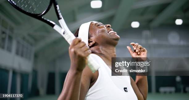 female tennis player extremely happy about her performance - persistência imagens e fotografias de stock