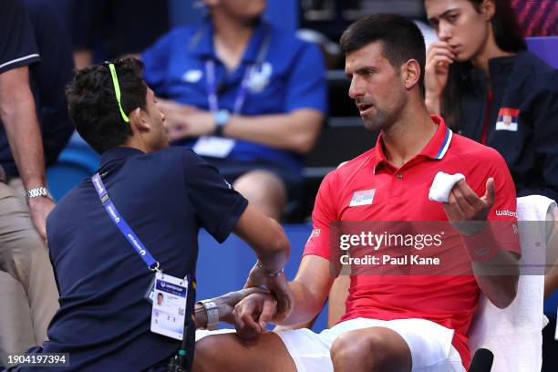 Novak Djokovic of Team Serbia receives treatment to his right arm during his singles match against Alex de Minaur of Team Australia during day six of...