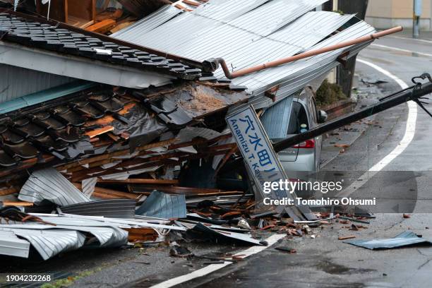 Car is seen under a collapsed house following an earthquake on January 03, 2024 in Anamizu, Japan. A series of major earthquakes have reportedly...