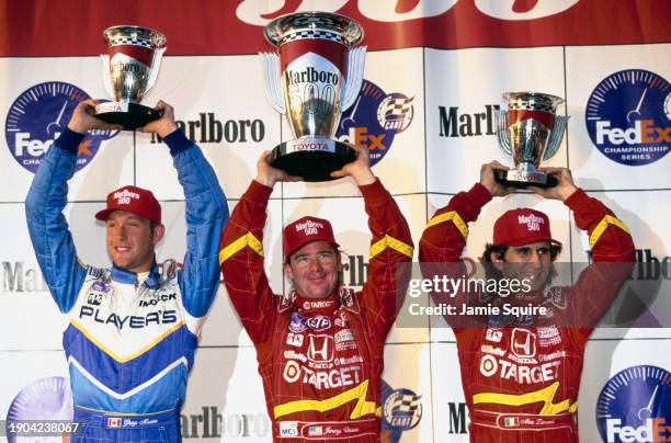 Jimmy Vasser from the United States, driver of the Target Chip Ganassi Racing Reynard 98i Honda HRK holds aloft the trophy alongside second placed...