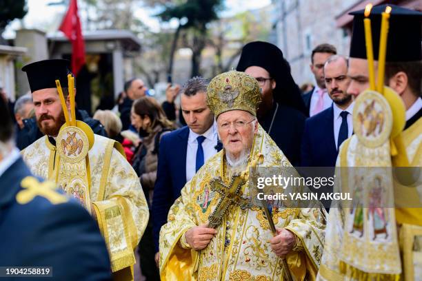 Greek Orthodox Church's Ecumenical Patriarch Bartholomew holds a wooden cross beside the Bosphorus river's Golden Horn, as part of celebrations of...