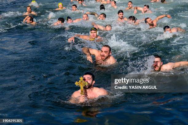 Kostas Kypros , a Greek Orthodox pilgrim from Alexandroupoli, kisses a wooden cross after he retrieved it from the Golden Horn during a celebration...