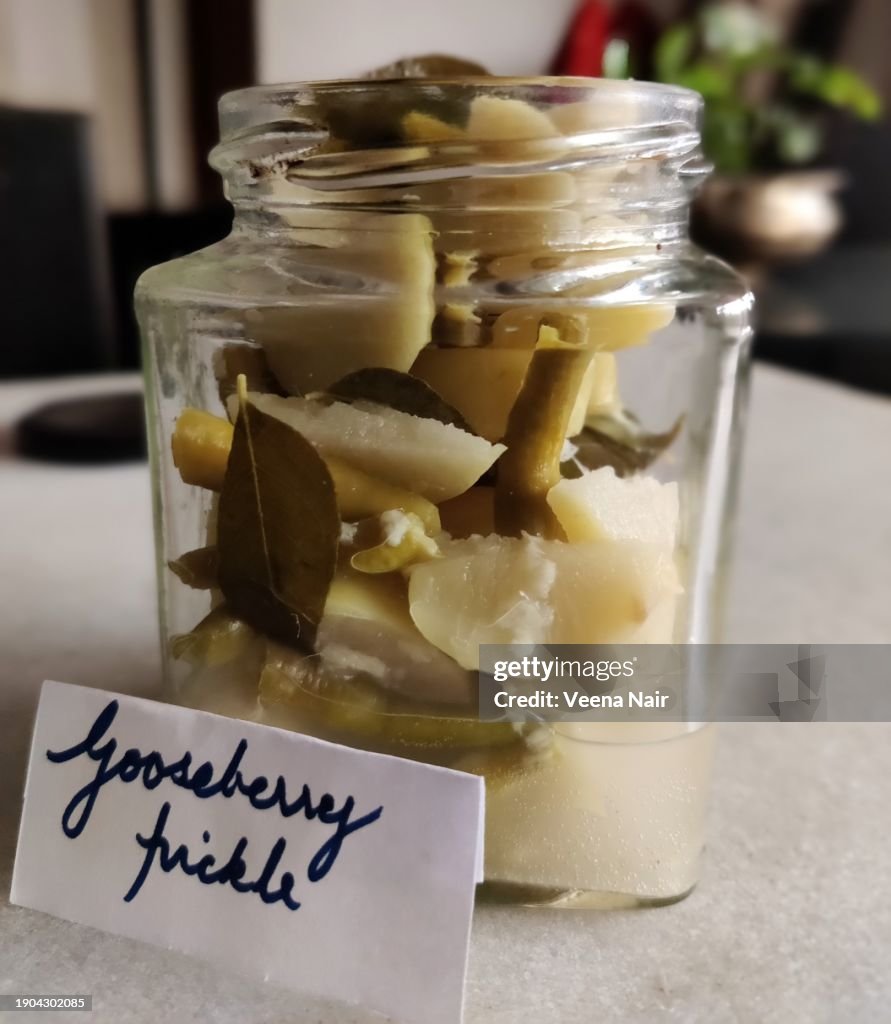 Raw Gooseberry/Amla Pickle with green chili, curry leaf and ginger in a glass jar/Handwritten tag/Still life