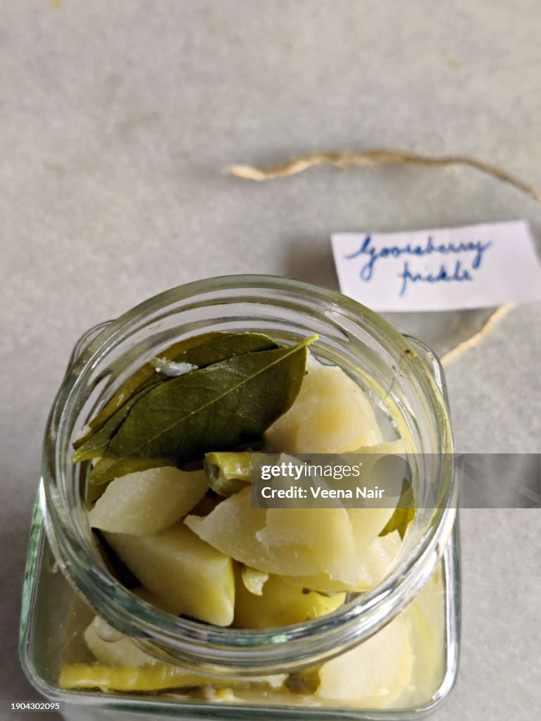 Raw Gooseberry/Amla Pickle with green chili, curry leaf and ginger in a glass jar/Handwritten tag/Still life