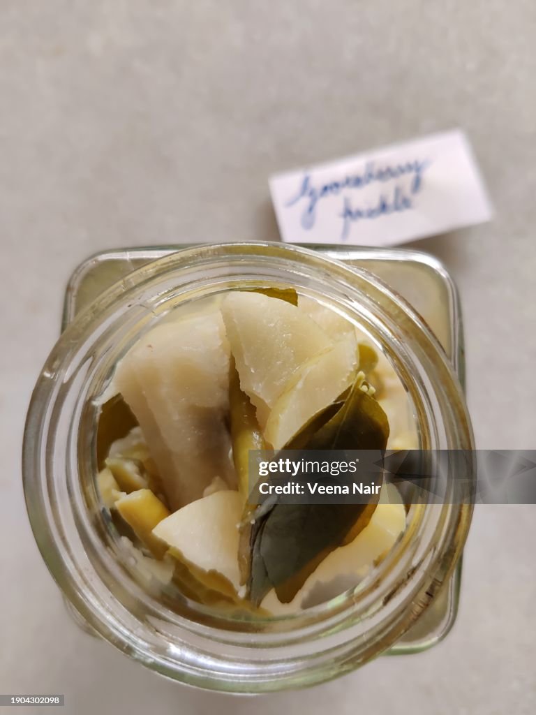 Raw Gooseberry/Amla Pickle with green chili, curry leaf and ginger in a glass jar/Handwritten tag/Still life