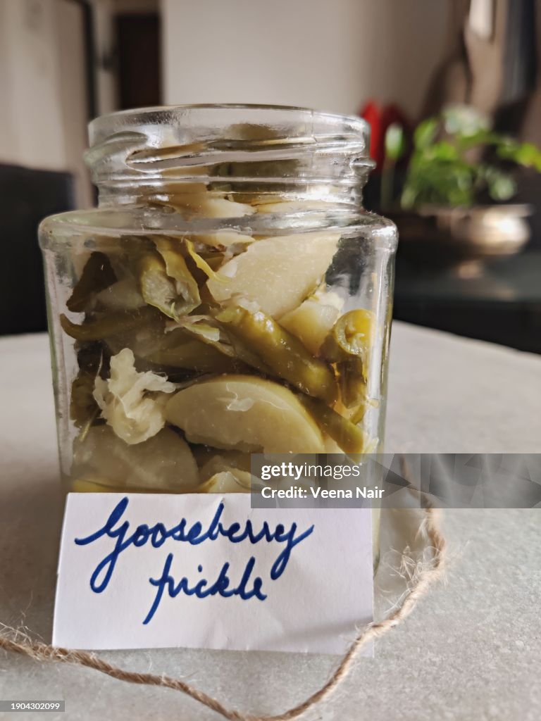 Raw Gooseberry/Amla Pickle with green chili, curry leaf and ginger in a glass jar/Handwritten tag/Still life