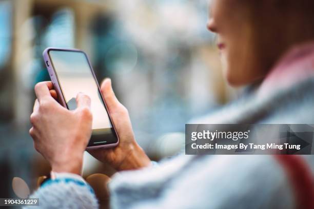 cropped shot of an asian woman using smart phone while enjoying coffee break at sidewalk cafe - one mid adult woman only stock pictures, royalty-free photos & images