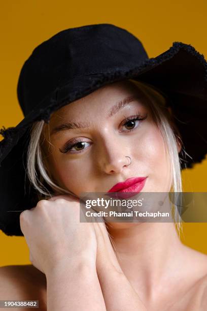 beautiful woman on plain background - close up of beautiful young blonde woman with black hat stock pictures, royalty-free photos & images