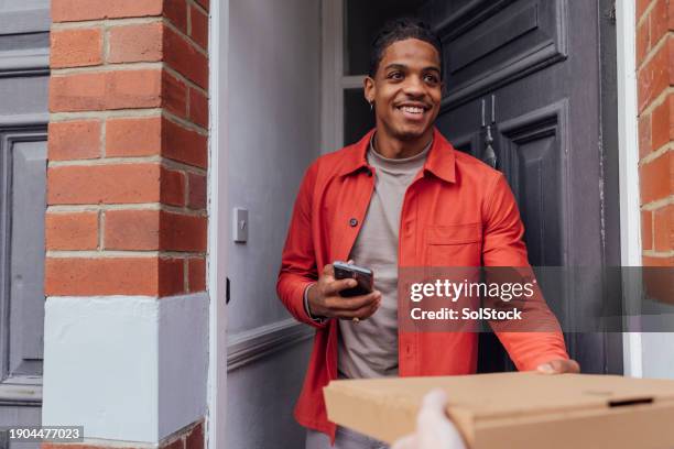 accepting a pizza at a house party - supply chain stock pictures, royalty-free photos & images