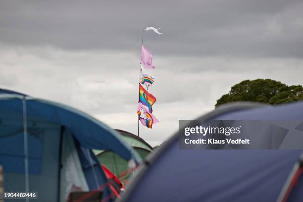 flags on pole fluttering in wind near camping tents - social awareness symbol stock pictures, royalty-free photos & images