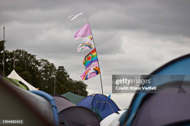 flags on pole fluttering in wind amidst tents - social awareness symbol stock pictures, royalty-free photos & images