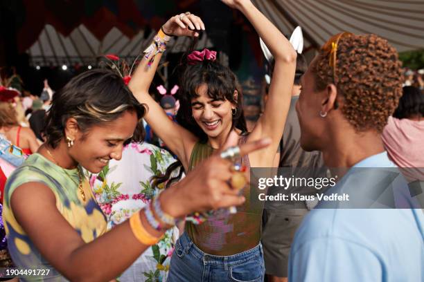 happy festival goers dancing while enjoying at concert - festival goer stock pictures, royalty-free photos & images