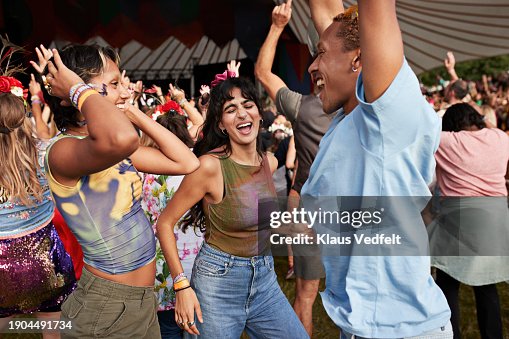 Happy man and women dancing at concert Happy man and women dancing at concert