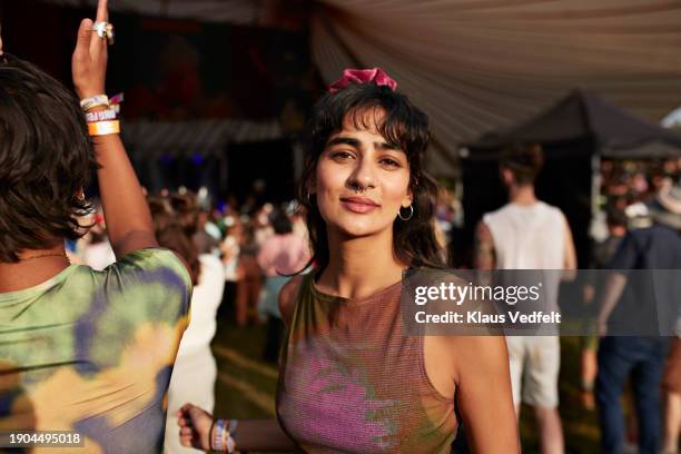 smiling woman dancing by friend at music concert - 24 year old woman stock pictures, royalty-free photos & images