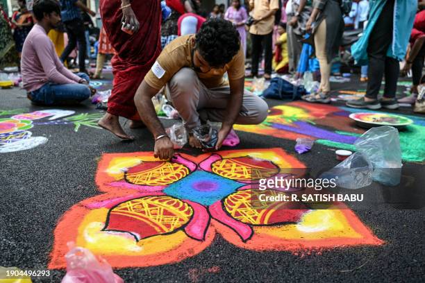 Man draws 'Kolam', a traditional decorative art, on a street during a contest on the occasion of Mylapore festival in Chennai on January 6, 2024.