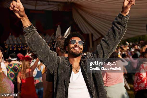 young man dancing with arms raised - festival day 1 stock pictures, royalty-free photos & images