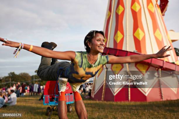 happy woman with arms outstretched balancing on legs - heteroseksueel koppel stockfoto's en -beelden