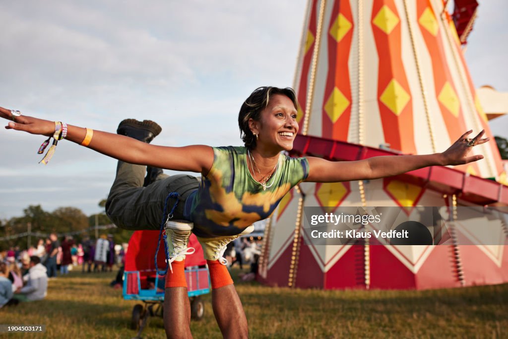 Happy woman with arms outstretched balancing on legs
