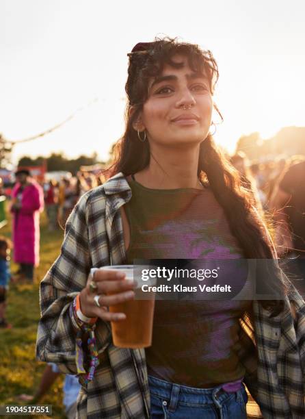 smiling woman with beer glass at music festival - one mid adult woman only stock pictures, royalty-free photos & images