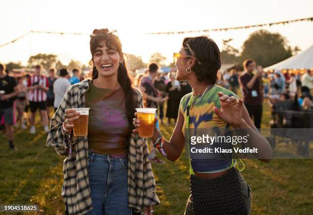 cheerful female friends dancing with disposable glasses - alcool stock pictures, royalty-free photos & images