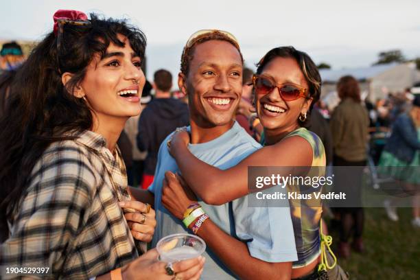 happy woman hugging boyfriend near female friend - ocio fotografías e imágenes de stock