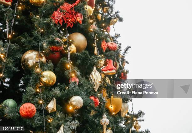 festive decorated christmas tree in the city, sustainable christmas concept, fir tree with illuminating and colorful garland - pinetree garden seeds stock pictures, royalty-free photos & images