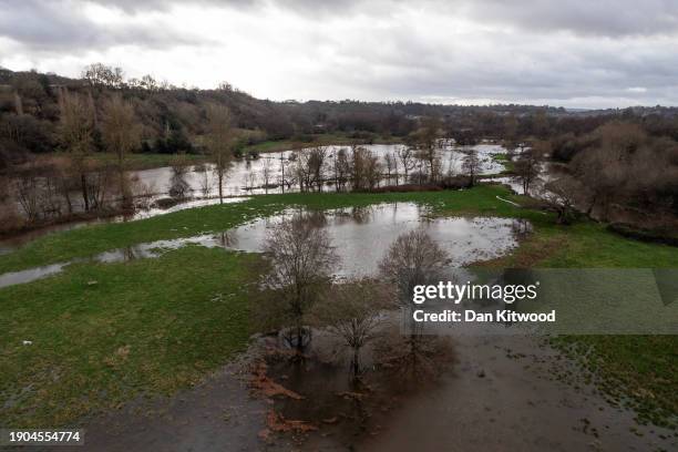 The River Wey bursts it's banks flooding fields on January 03, 2024 near Godalming, United Kingdom. The Met Office issued over 300 warnings for...