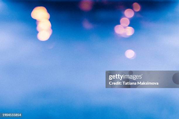 a textured blue background with grains and glimmers from the glow of street lamps, cinematic night ambiance. - filme cinematográfico imagens e fotografias de stock