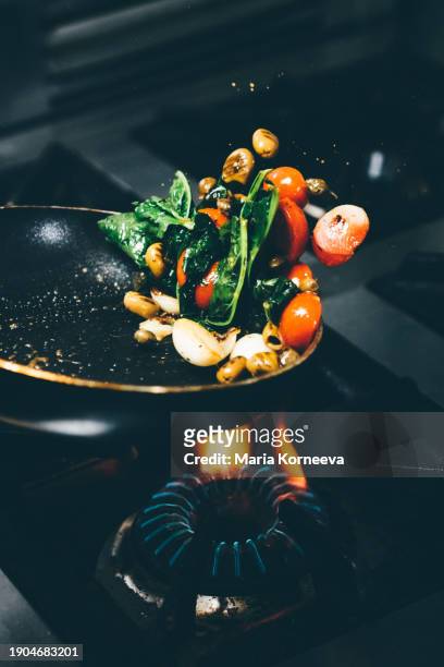 chef frying vegetables in a pan. - chef tossing fire stock-fotos und bilder